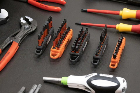 Screwdriver Bit Holder Storage Organizer 10 Hole Orange Bit Holder With Carabiner 2 Pack on workbench with assorted tools.