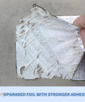 Close-up of Heavy Duty Butyl Waterproof Tape 20 Inch By 32.8 Feet Aluminum Foil Backed Seal Strip being applied on concrete surface.