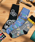 Three Pack Mechanical Engineering Socks Gift Set For Gearhead Men And Techy Dads with gear and tool prints on a wooden table.