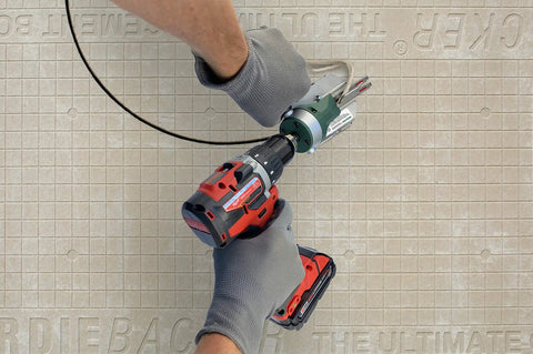 Person using Snapper Shear Pro Drill Attachment For Fiber Cement Board Cutting HardieBacker One Quarter To One Half Inch Thick With Any 18 Volt Or Higher Cordless Drill Contractor Grade For Cutting Any Shape on cement board.
