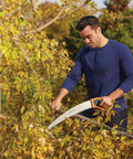 Man using PowerTooth D Handle Hand Saw with razor sharp stainless steel blade for quick cuts on tree branches
