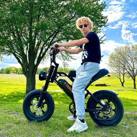 Teen riding Raw Power 1000W Fat Tire Electric Bike for Teens and Kids 48V 15.6Ah in park setting, showcasing bike design