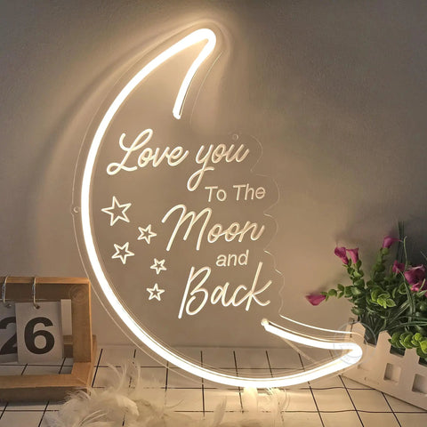 Moon Neon Light Sign With Love You To The Moon And Back 3D Art, warm white glow, USB powered, on table with decor items.