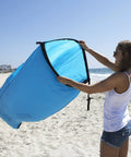 Person holding Inflatable Lounger Air Chair Lightweight Self Inflating Beach Chair with Carry Bag Ground Stakes for beachside lounging