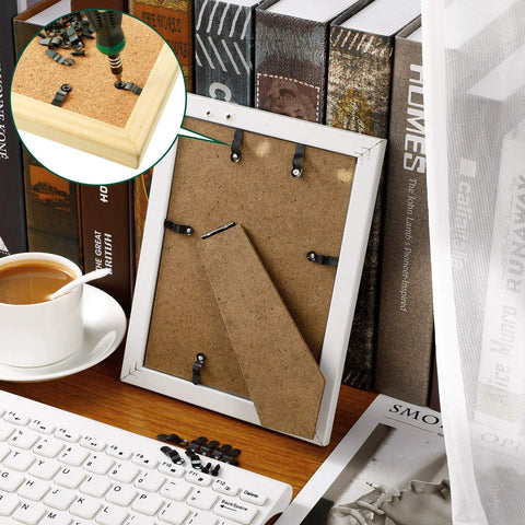 Back view of white picture frame with metal turn-button fasteners and screws for hanging photos.