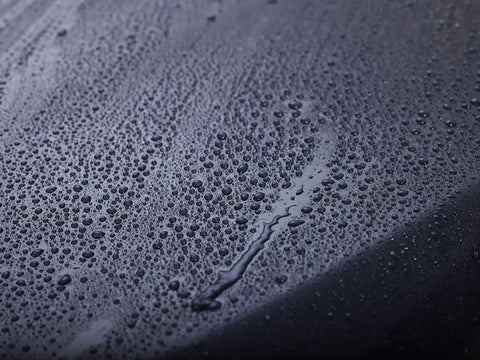 Close-up of water beading on a surface treated with Touchless SiO2 Shield Sealant For Paint, Glass And Wheels, Water Activated, Spray On