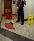 26 Inch Heavy Duty Yellow Caution Sign For Slip Hazards And Wet Floors Twin Sided High Visibility Standup Floor Sign in use by a worker.