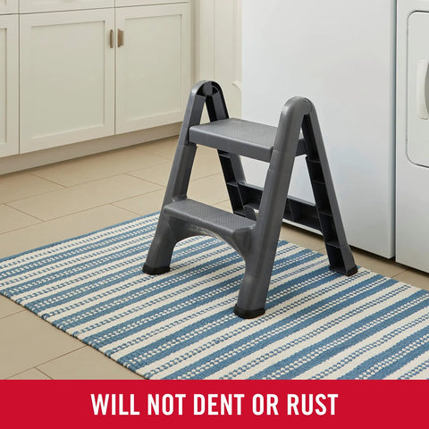 Two Step Folding Foot Stool 14 Inch High Gray Lightweight 300 Pound Capacity in kitchen on striped rug