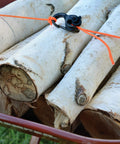 Beefy Aluminum Rope Tightener With Cam Lock And Quick Release securing birch logs, showing outdoor use for camping and hiking.