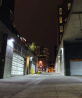 Bronze Outdoor LED Full Cutoff Emergency Wall Pack With Photocell 5000K lighting an urban outdoor alley at night