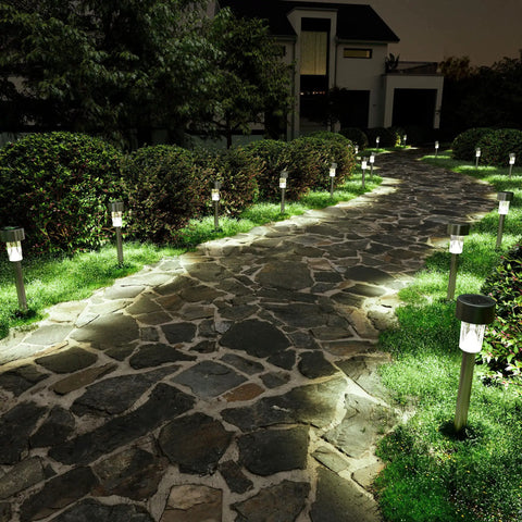 12 Pack Solar Pathway Lights Stainless Steel Outdoor LED Landscape Lights For Walkways Patios Lawns Yards And Driveways IP55 Waterproof Easy Setup Cold White Glow All Weather No Fuss Maintenance Free illuminating a stone pathway at night
