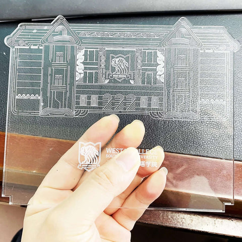 Front view of a clear square acrylic sheet, 5.9 in by 5.1 in, 4 mm thick, with protective film, held by hand.