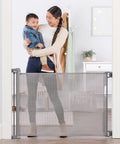 50 Inch Wide Retractable Baby Gate For Doorways And Hallways, Mesh Safety Barrier For Babies Toddlers And Pets, shown in a hallway