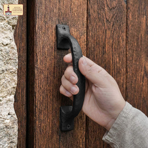 Hand holding Twisted Grip Mystic Colonial Rustic 6.5 Inch Barn Door Handle Pull For Sliding Barn Doors Built Tough With Black Wrought Iron