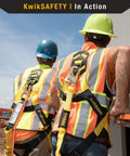 Two workers wearing KwikSafety vests with Double Leg Rattler Y-Leg Safety Lanyard With Internal Shock Absorber, 6 Foot, in construction area.