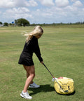 Golfer using Golf Impact Bag Swing Trainer for Point of Impact Practice, Waterproof and Durable on grassy course.
