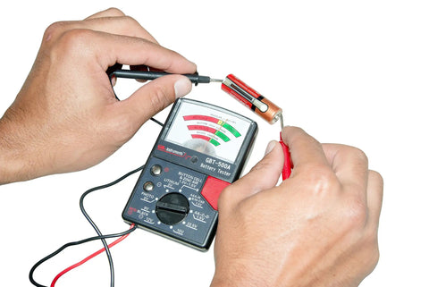 Analog Battery Tester With Test Leads For All Common Batteries From 1.5V Button Cells To 12V Lantern Batteries, AA And AAA, 9V, 14 Battery Range, Easy Read Meter, Black in use testing a AA battery.