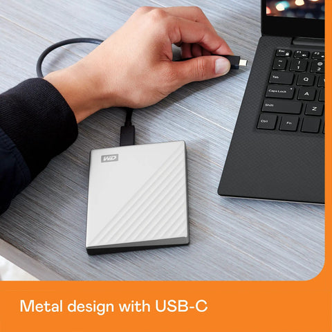 Hand connecting 2TB My Passport Ultra Portable External Hard Drive With Ransomware Defense And Password Protection USB C And USB 3.1 Silver Finish to a laptop