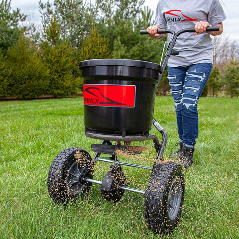 50 Lb Capacity Push Broadcast Spreader For Lawns And Gardens, Easy Push Handle, Durable Heavy Duty Frame in use on grass