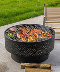 26-Inch Wood Burning Fire Pit Table With Grill And Lid For Outdoor Use showing BBQ with food on geometric cutout design.