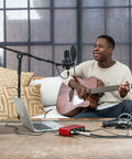 Person using Scarlett Solo 3rd Gen USB Audio Interface Bundle With LyxPro Cardioid Condenser Mic for home studio recording.