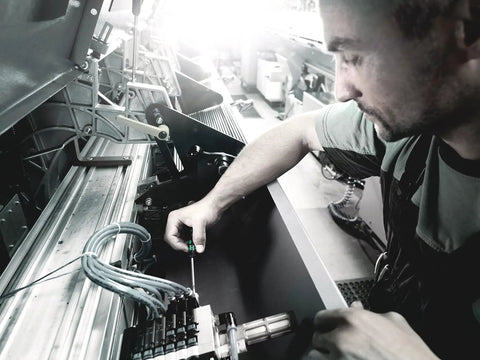 Technician using Kraftform Micro Ball End Hex Pro Grade Screwdriver Set for precision electronics adjustment at a workstation.