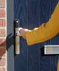No Sweat Smart Keyless Front Door Handle With Polished Brass Finish And Smartphone App Control For Zero Stress Home Security in use.