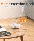Surge Protector Power Strip With Eight Outlets And USB C Plus USB A Ports 5 Ft Flat Plug Extension Cord next to a table on wood floor.