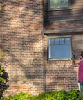 Person using Go-To Rechargeable Power Wand With 3 Way Spray Nozzle And 3.6V Lithium Ion Battery on brick house wall