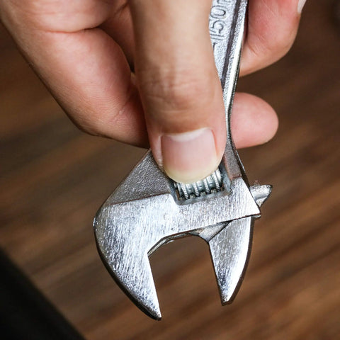Close-up of hand holding Six Inch Adjustable Wrench With Hex Jaw Opens To Three Quarter Inch SAE And Metric Sizes Etched