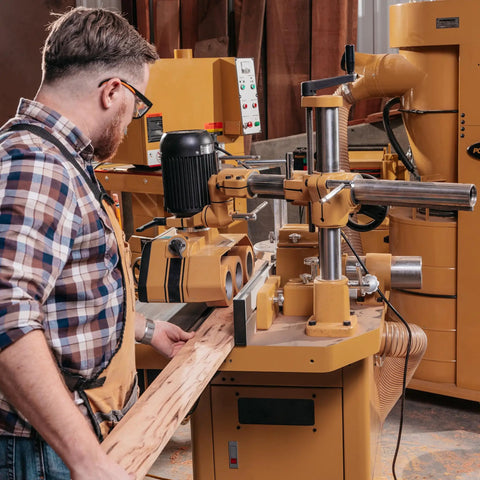Solid As A Rock Three Roll Power Feeder With Heavy Duty Gear Driven Chain System And One Horsepower Motor used for wood feeding on a workbench.