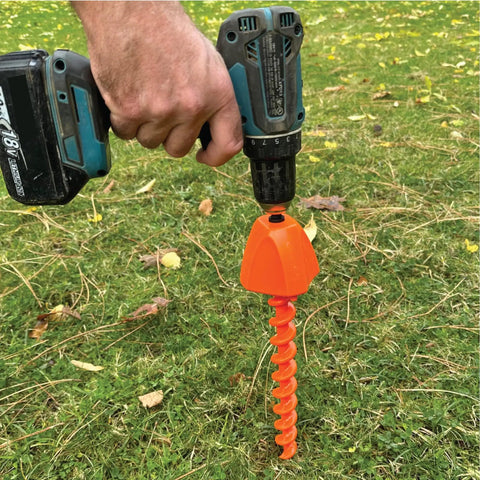Screwdriver 2.0 Drill Attachment For Quick Ground Screw Installation And Removal in use with cordless drill on grass