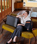 Woman sitting with Airline Approved Carry On Luggage 22x14x9, 20 Inch ABS Hard Shell Suitcase With TSA Lock beside her on a retro couch.
