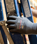 Worker wearing 12 Pack Safety Performance Series Work Gloves For Construction And Mechanics Heavy Duty With Breathable Flex handling ladder.