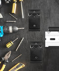 12 Pack Din Rail Mounting Clips One Point Oh Eight Inch Wide Snap In Universal Black Aluminum Alloy Relay Clips for 35mm Din Rail Switches and Injectors Durable Easy Install Great for Electrical Panels and Enclosures, shown with assorted tools on a workbench.