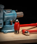 Dead Blow Ball Peen Hammer 36 Oz Orange Handle next to blue vise, ideal for metalwork and automotive repairs, reduces rebound.