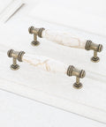 Solid As A Rock Cabinet Door Pulls Set Of Four Marble Ceramic Handles Heavy Duty Zinc Base Anti Rust Finish Easy No Sweat Install 3.78 Inch Center Spacing For Kitchen Hardware close-up view of two bronze handles with marble ceramic ends on white background.