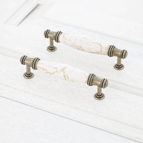 Solid As A Rock Cabinet Door Pulls Set Of Four Marble Ceramic Handles Heavy Duty Zinc Base Anti Rust Finish Easy No Sweat Install 3.78 Inch Center Spacing For Kitchen Hardware close-up view of two bronze handles with marble ceramic ends on white background.
