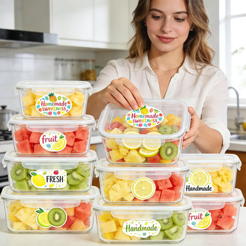 Woman stacking clear containers labeled 'Homemade Sweetness' with mixed fruit in a kitchen.