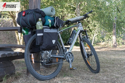 Bicycle loaded with camping gear secured by Ultimate Flat Outdoor Bungee Cord Set, 28 Heavy Duty Cords In 18, 24, 32, And 40 Inch Lengths
