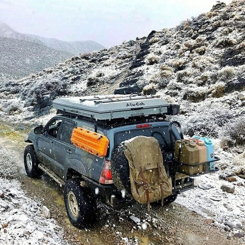 SUV with Portable 5 Gallon Military Style Water Jug For Camping And RVs on a snowy trail