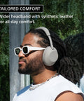 Man wearing Top Tier Noise Canceling Wireless Headphones With HD NC Processor QN3, white synthetic leather headband, outdoors