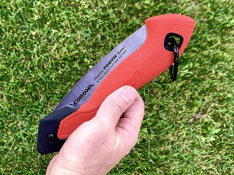 7 Inch Folding Pruning Saw With Fast Cut Razor Tooth Blade Heavy Duty Hand Tool held in hand, showcasing ergonomic grip on grass.