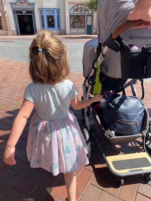 Toddler holding detachable stroller handle for child safety keeps kids close and ready for travel must-have accessory for strollers