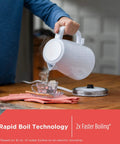 1.7L Cordless Electric Kettle With Rapid Boil, Auto Shutoff, And Water Window, Premium Textured Finish in White pouring water into a cup.