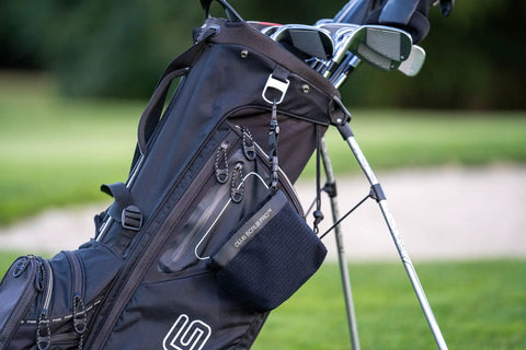 Golf Club And Ball Cleaning Bag With Waterproof Liner And Clean Face Technology attached to a golf bag on a course