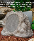 Rock Speaker Connect Stone Outdoor Wireless Speaker With Bluetooth 5.3 blending into garden setting, featuring stone texture and speaker grill