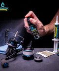 Spray bottle from Marine Reel Care Kit with oil and grease for freshwater and saltwater reels, surrounded by maintenance tools.