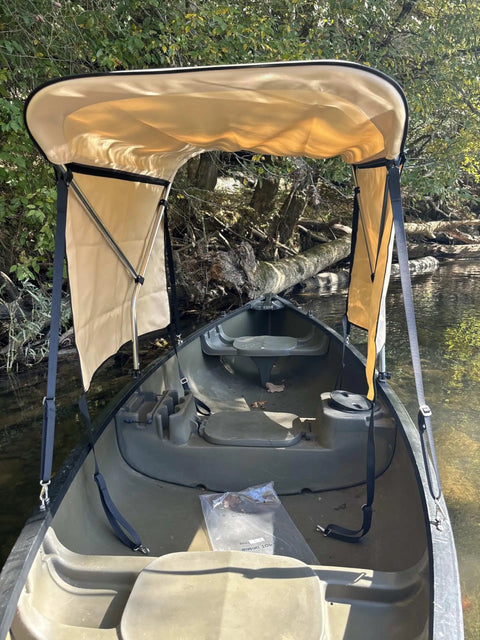 Beige Canoe And Kayak Sun Shade Canopy Bimini Top In Conestoga Wagon Style with side curtains, mounted on a canoe.