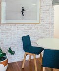 Dining area with Black Brick Textured Peel And Stick Wallpaper Removable Self Adhesive For Easy Diy Wall Makeovers No Mess No Glue 20.5 Inch By 16.5 Foot Realistic Brick Look Made In USA, round table, and blue chairs.